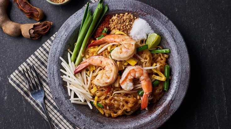 Popular Pad Thai Thai street food with stir-fried rice noodles, vegetables, peanuts, and lime