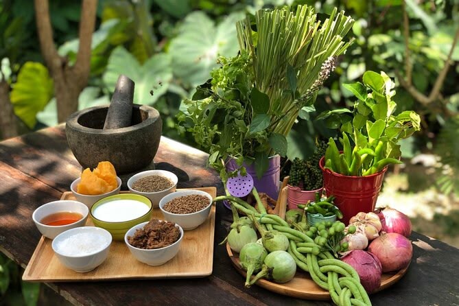 Fresh Thai herbs and aromatics including lemongrass, Thai basil, galangal, garlic, and chilies