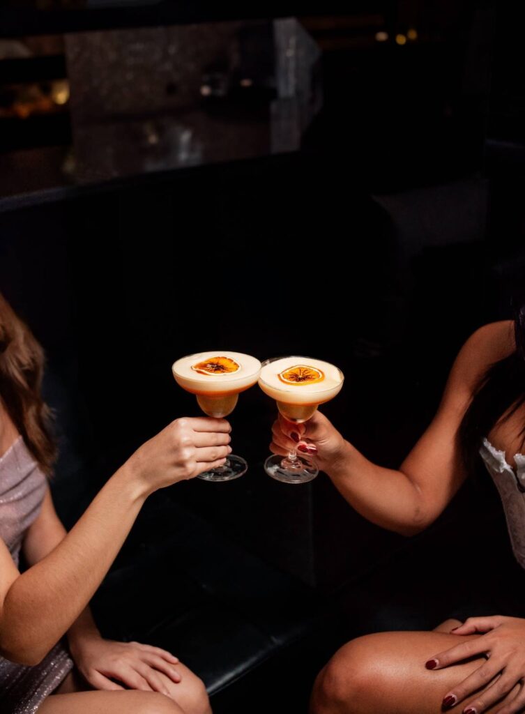 Friends enjoying cocktails and food at Indulge Bangkok